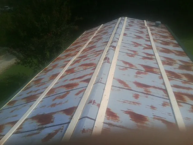 Rusted metal roof panels with new wood purlins before replacement — Storm Damage Roof Repair in Olive Branch by Roofing Brothers